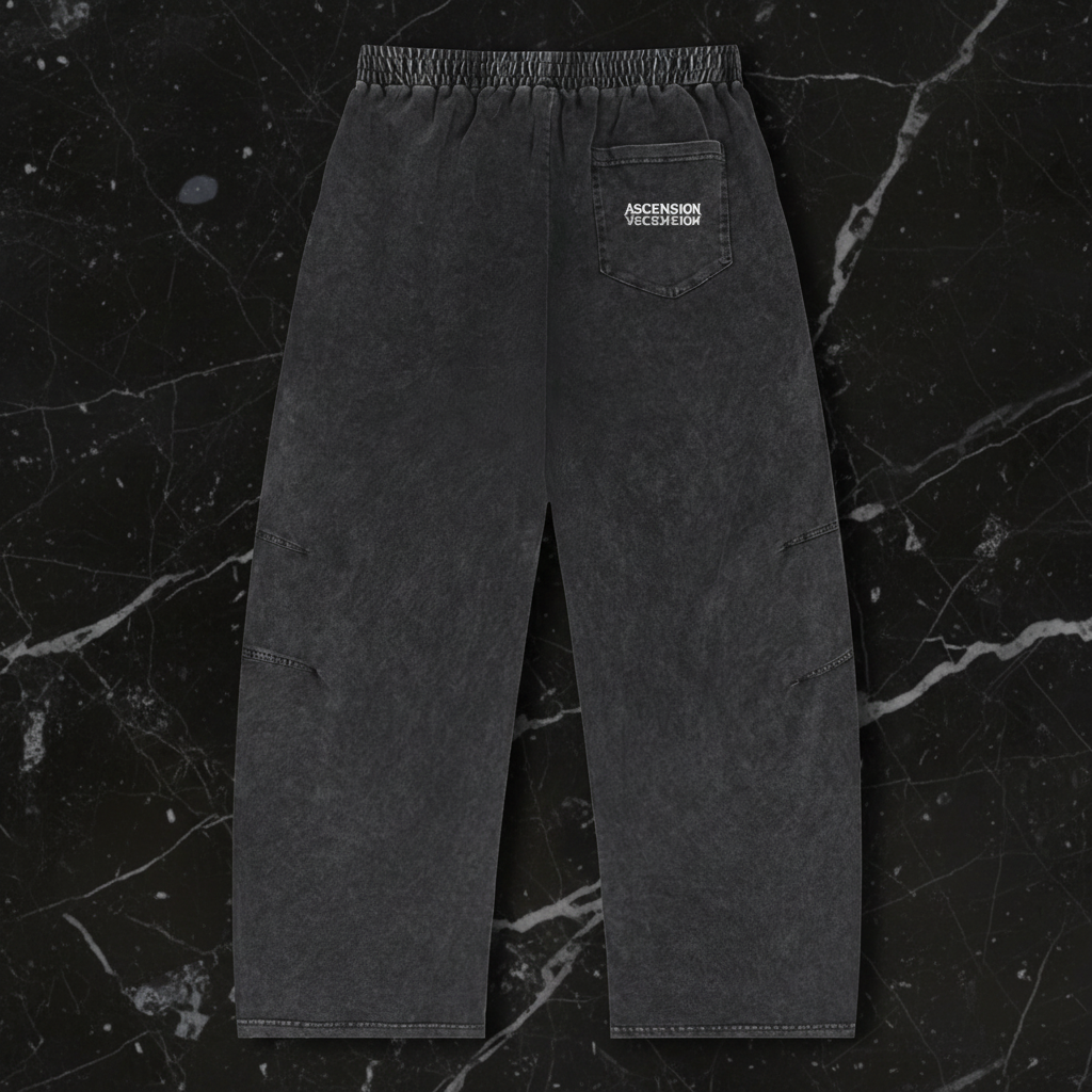 Dark gray pants with a brand logo on a black marble background