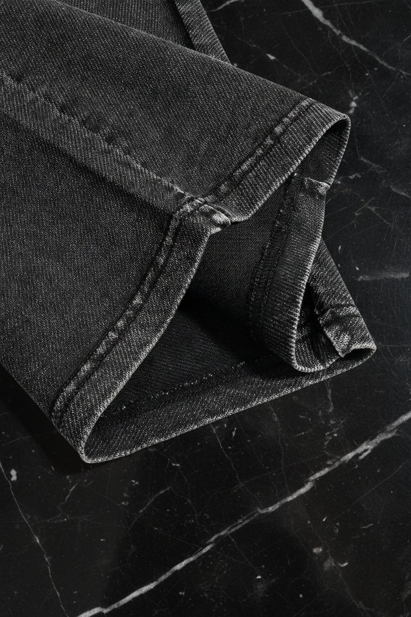 Close-up of black denim fabric with a white background