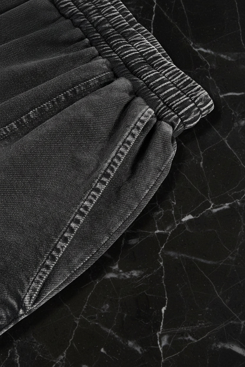 Close-up of black pants with a white background