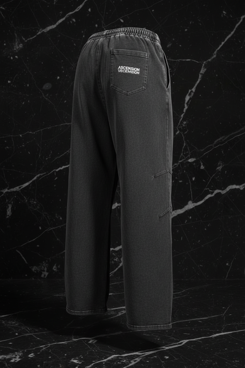 Dark gray pants with a brand label on a black marble background